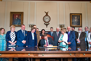photo of governor sununu signing hb 1221 while others look on