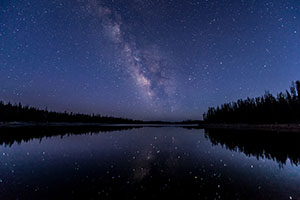 Night sky with Milky Way reflected in water.